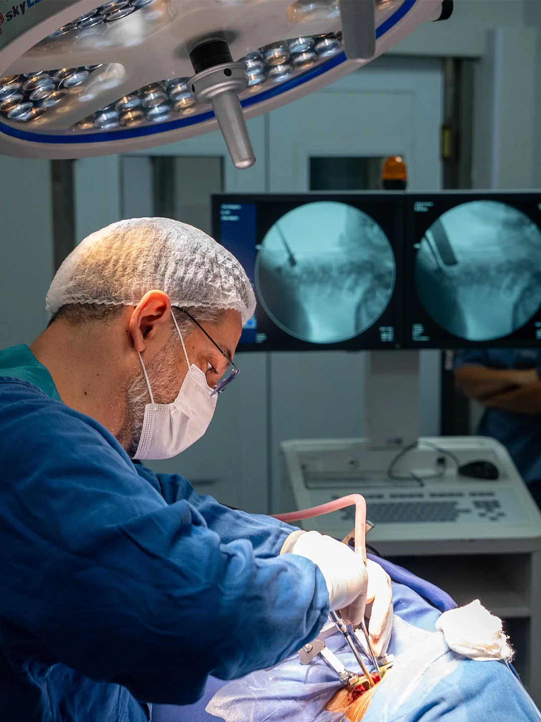 Dr. Vladmir Resende durante cirurgia de coluna com apoio de imagens médicas